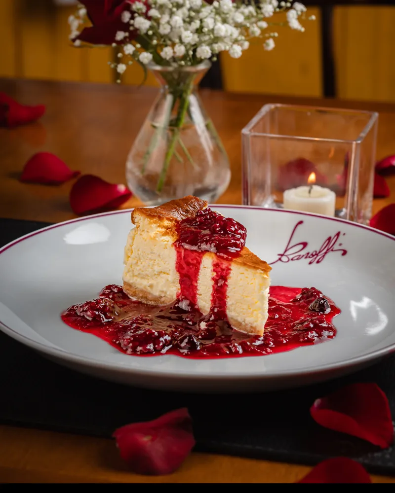Fatia de cheesecake com calda de amora no prato da Banoffi