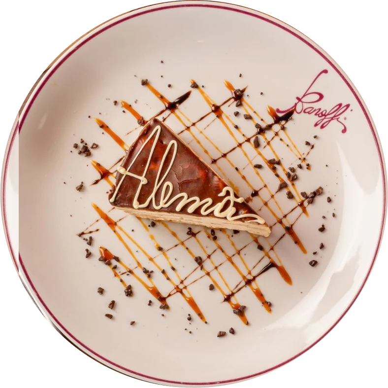 Torta alemã assinada em chocolate branco no prato da Banoffi, vista de cima